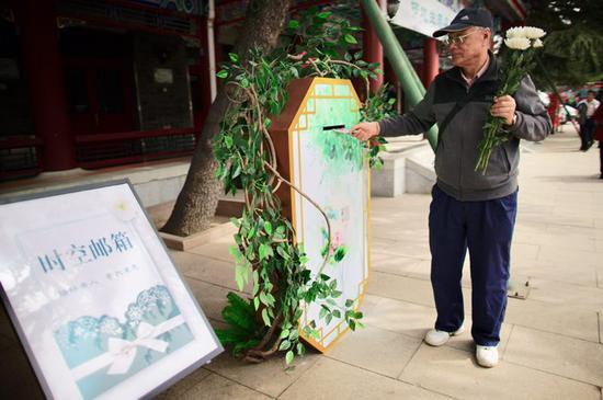 一位老人向新设置的“时空邮箱”中投入信件。新京报记者 郑新洽 摄