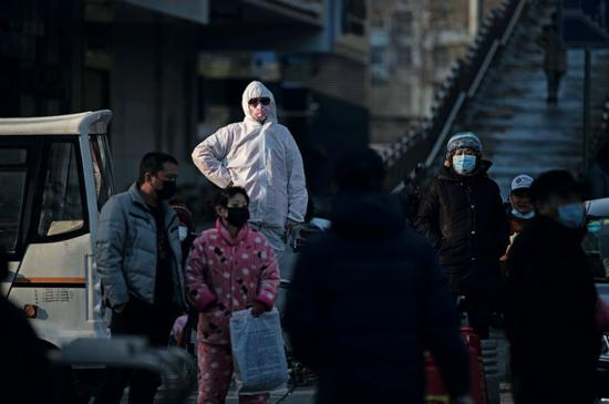 　　1月31日，在武汉市汉口新华路，一些送疑似新冠病毒感染者去医院确诊的家属站在路边等消息。摄影/长江日报 金思柳