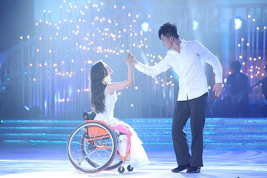 廖智坐着轮椅（左）和舞伴跳舞&nbsp; 视觉中国 图