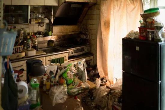 　　孤寡老人Kinoshita的公寓一角。房间里堆满垃圾，却摆着三四床全新的羽绒被，那是推销员利用老年孤独心理上门诈骗的杰作。Ko Sasaki摄