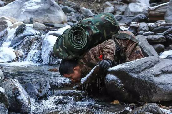 2018年1月10日，西藏一条边防线上，一名巡逻战士俯下身来喝冰水。