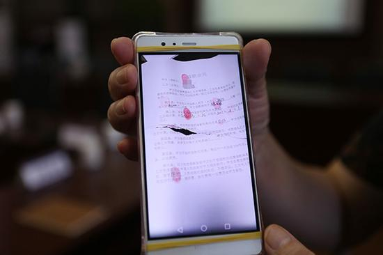 一名受害人出示套路贷的合同。视觉中国 资料