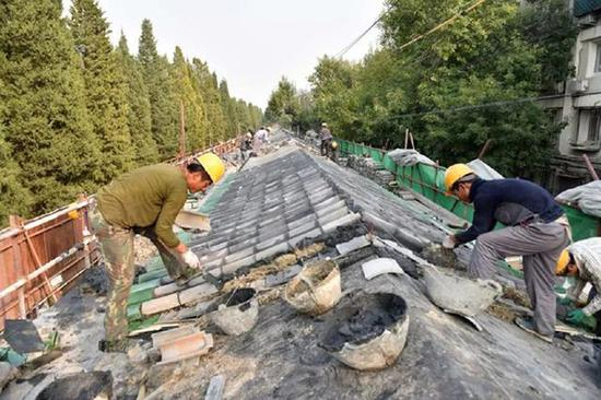  10月13日，天坛核心区搬迁腾退工作完成之后，工人们正在修复残破的天坛内坛南墙。