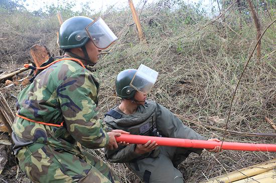 杜富国正与战友一起设置扫雷爆破筒，左侧为杜富国。杨萌 摄