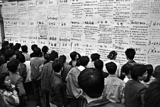 1989年，海口市东湖“人才墙”聚集的闯海人。摄影|黄一鸣