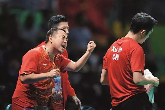 　　△2016年里约奥运会乒乓球男团决赛中，中国队员许昕（右）以2：3不敌日本队员水谷隼输掉第二场比赛。在许昕参加下一场双打比赛前，刘国梁为他加油。