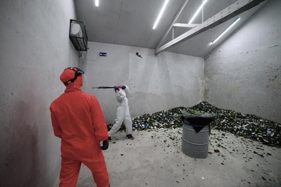 “发泄屋”的顾客正在房间内体验打砸发泄。　摄影/新京报记者 郑新洽