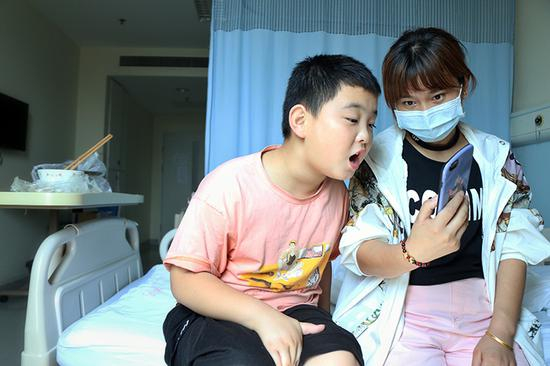 ▲&nbsp;路子宽和姑姑给在15楼的爸爸打视频电话，鼓励爸爸“要坚强”。&nbsp; 图片来源：新京报