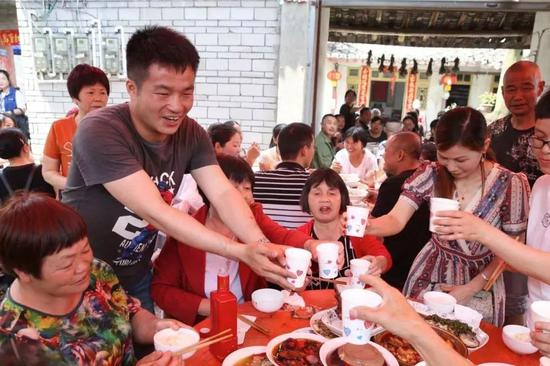 　　2019年5月14日，四川崇州市三江镇王桥村。王永福正在给前来道喜的亲朋敬酒。新京报记者 尹亚飞 摄
