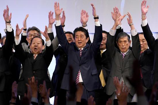 ▲2018年5月自民党党代会结束后，日本首相安倍带领大家一起欢呼。 |视觉中国