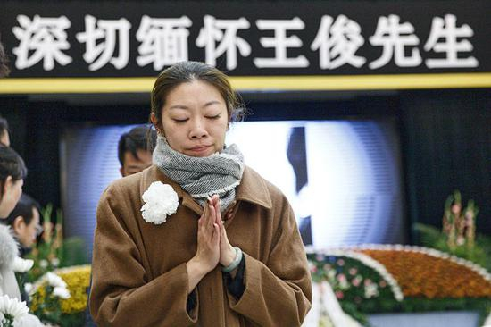 悼念者双手合十，送别王俊。