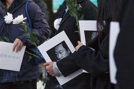 悼念者手持王俊的生平介绍。