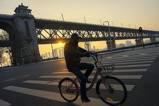 2月4日，一名市民在武汉长江大桥附近骑车。 新华社&nbsp; 图