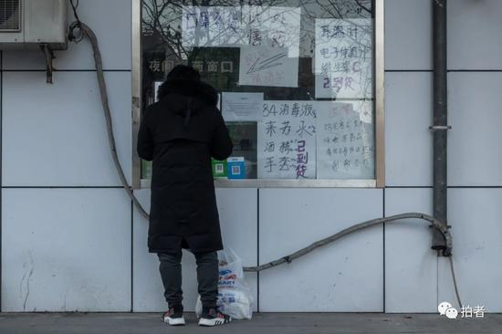 　△&nbsp;3月4日，利泽西园小区附近，市民在药店买药。疫情期间，许多药店都通过小窗口向居民售药。