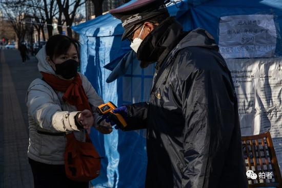 △&nbsp;3月4日，北京望京，华鼎世家B门，保安正在为居民测量体温。