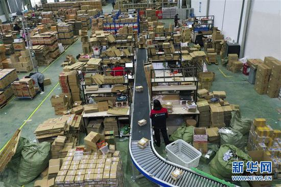 　　2月27日，在重庆秀山（武陵）现代物流园区的电商云仓内，电商企业的工作人员按照订单将打包好的快递放到自动化快递分拣流水线上。 新华社记者 刘潺 摄