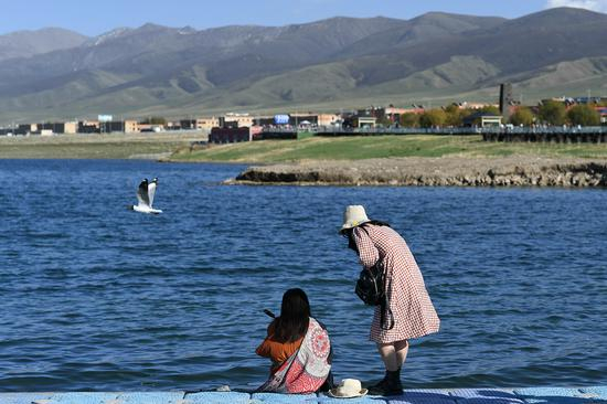 2021年6月，游客在青海湖二郎剑景区内游玩。新华社记者 吴刚 摄