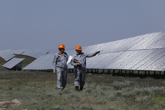 5月4日，在哈萨克斯坦阿拉木图州的卡普恰盖100兆瓦光伏电站内，工作人员监测太阳能电池方阵情况。（新华社发，奥斯帕诺夫摄）