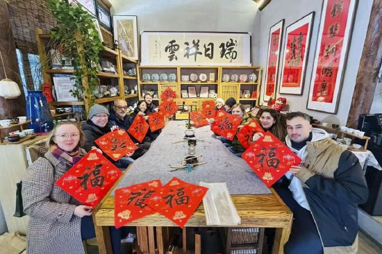 2025年12月，外国游客在北京大栅栏街区体验中国书法。新华社记者 周心怡 摄