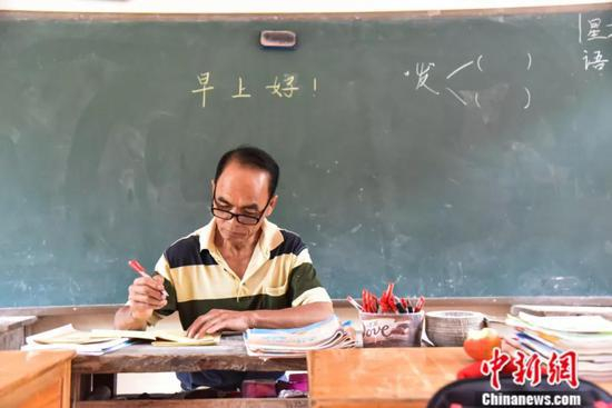 周宏军早上到教室后先批改作业。