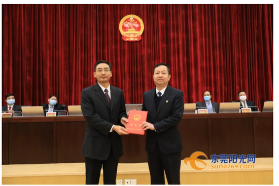 图为东莞市人大常委会常务副主任潘新潮为周兆翔（右）颁发任命书（图/东莞阳光网）