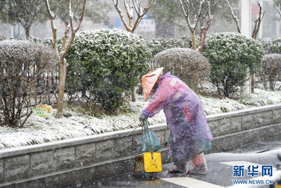 在武汉市汉口火车站，一名环卫工人在雪中工作（2月15日摄）。 新华社记者 才扬 摄