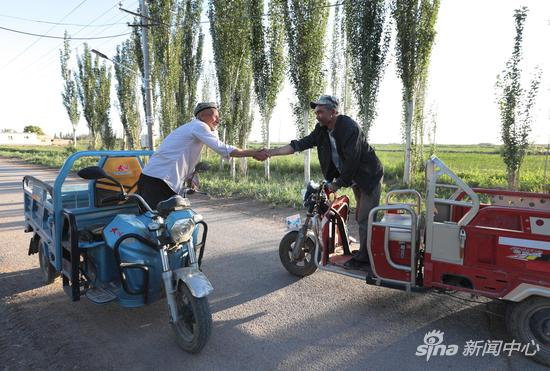 多提巴格乡村道上停车握手的村民。