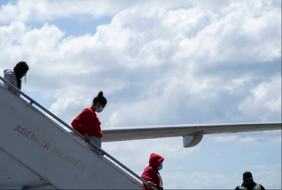 2月14日，在洪都拉斯西北部城市圣佩德罗苏拉的拉蒙·比列达·莫拉莱斯机场，返乡移民走下飞机。新华社发（戴维摄）