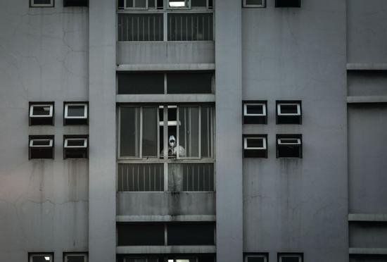 　　1月20日，武汉市金银潭医院南楼，一名医护人员站在窗口透气。最早的新冠重症病人都收治于此。摄影/厉禹王