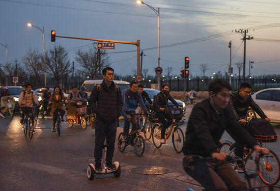 西二旗后厂村路路口，一名男子骑电动平衡车过马路。据说这里以名字土和堵车闻名。