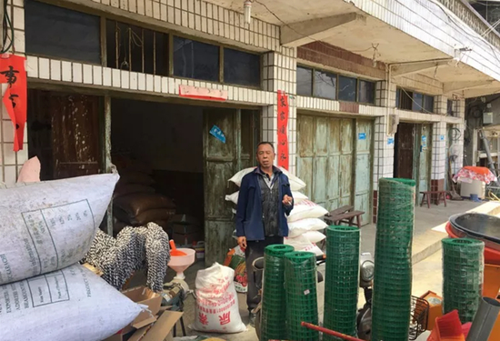 ▷ 杨志芬站在当年的案发现场——门店房前和邻居打招呼