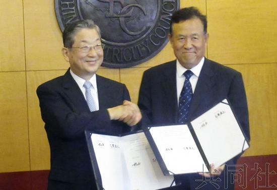 日方代表志贺俊之（左）与中方代表中国电力企业联合会常务副理事长杨昆（右）