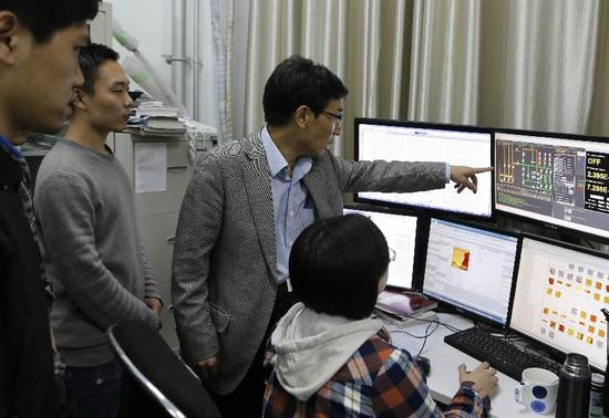 ▲清华大学副校长薛其坤教授在实验室指导学生。 &nbsp;图/新华社