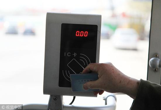　　▲2014年3月30日，江苏省南京市，一名老年乘客在公交车的刷卡机上刷老人免费卡乘坐公交车。 图片来源：视觉中国