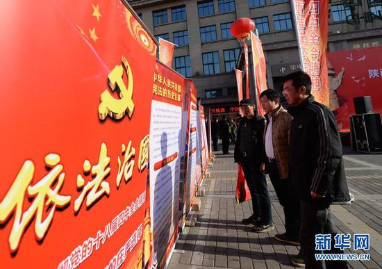 　　西安市民在国家宪法日宣传活动现场观看依法治国宣传展板（2014年12月4日摄）。新华社记者 李一博 摄