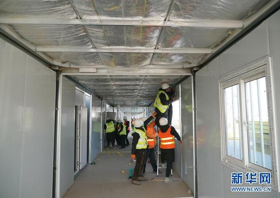 1月18日，在河北省石家庄市黄庄公寓隔离场所项目工地，工人在安装集成房屋。新华社记者 杨世尧 摄