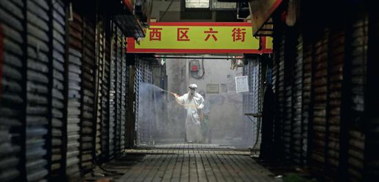2月22日，工作人员给封闭中的武汉华南海鲜市场进行消毒。摄影/解放日报 赖鑫琳