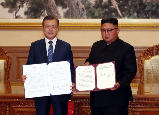 ▲9月19日，金正恩（右）与文在寅在签署《9月平壤共同宣言》后合影。 图/新华社