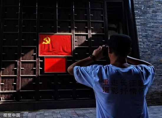 ▲一位摄影师在拍摄党旗。