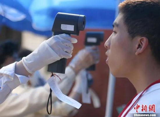 　　资料图：2003年6月7日，“非典”时期的高考如期举行。为保障考生安全，所有考生须测试体温。中新社发 史利 摄 图片来源：CNSphoto