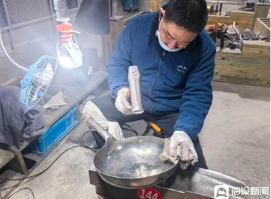  正在锻打章丘铁锅的匠人。