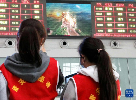 1月2日，青年志愿者在福州火车站候车厅观看大屏幕播放的主题歌曲《领航》MV。新华社发（李一明 摄）