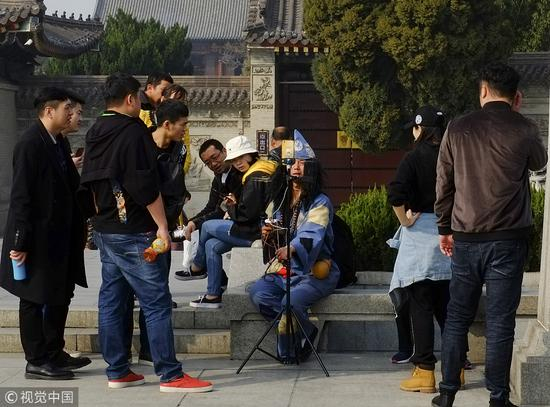 ▲2018年3月，西安一小伙街头扮济公玩直播，吸引众多游客围观。图/视觉中国