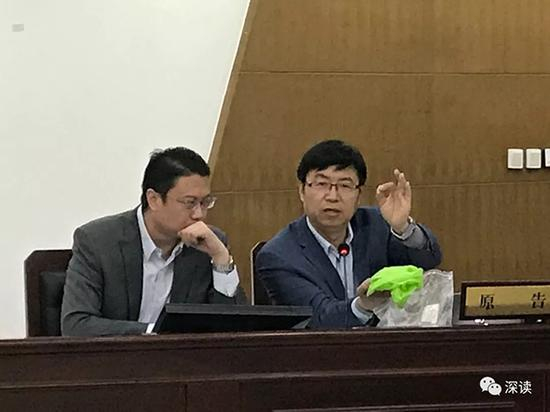 原告律师拿出玻璃杯碎片 本文图均为 深读微信公众号 图