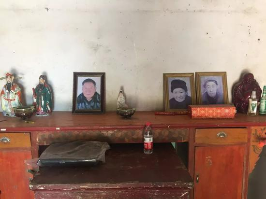 周继坤在大周庄的家里，父亲的遗像摆在客厅的木桌上。新京报记者赵蕾&nbsp;摄