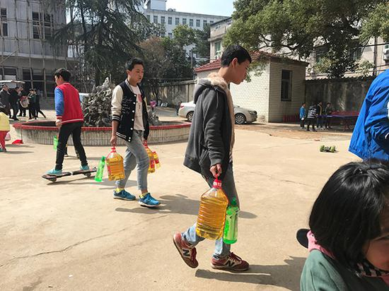 3月23日，爱心人士给子墨艺高送来食品等物资，彝族孩子帮忙搬运。澎湃新闻记者 张维 图