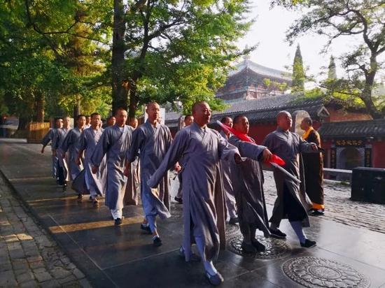 ▲少林寺僧人升国旗的途中 图片来源：少林寺官网