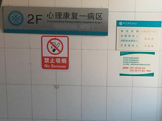 “心理康复一病区”的指示牌上有一部分内容被抹掉