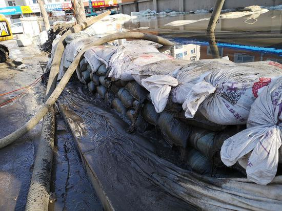 　　11月18日，龙山实验学校附近的仙人河桥东侧，竖井里的黑水被水泵抽入临时蓄水池，蓄水池在向外溢水。新京报记者 段睿超 摄