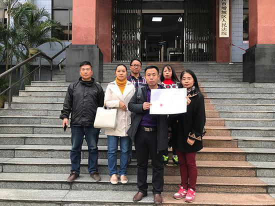 2018年12月28日法院宣判后，被拐儿童申聪的父亲和志愿者在一起。 受访者 供图